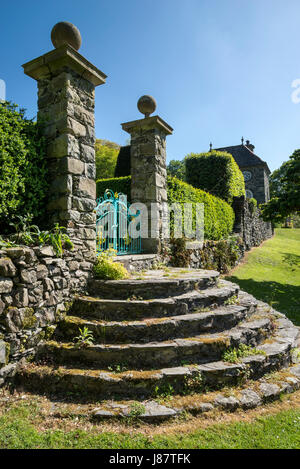 Gradini in pietra e cancelli ornati a Plas Brondanw giardini vicino Garreg, il Galles del Nord. Un bellissimo giardino creato da Clough Williams-Ellis. Foto Stock