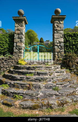 Gradini in pietra e cancelli ornati a Plas Brondanw giardini vicino Garreg, il Galles del Nord. Un bellissimo giardino creato da Clough Williams-Ellis. Foto Stock