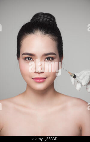Bella donna asiatica ottiene bellezza iniezioni facciali. Invecchiamento facciale iniezione. Foto Stock