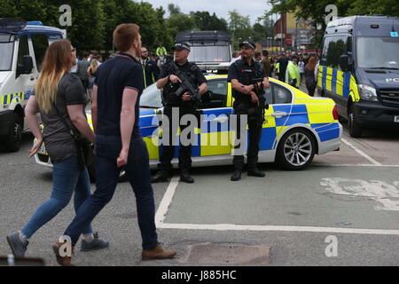 Armati di pattuglia di polizia in Lancashire Cricket Club di Old Trafford terra, davanti a un concerto per 50.000 appassionati di musica, come una grande operazione di sicurezza è in corso presso il primo grande evento che si terrà a Manchester poiché l attentato suicida a Manchester Arena nella città in precedenza questa settimana. Foto Stock