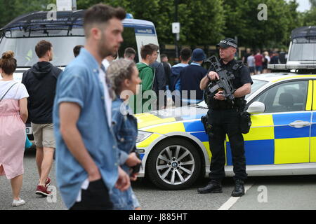 Pattuglia armata della polizia al Lancashire Cricket Club's Old Trafford Ground, prima di un concerto per 50,000 appassionati di musica, come un'enorme operazione di sicurezza è in corso nel primo grande evento che si terrà a Manchester dopo l'attentato suicida alla Manchester Arena, in città all'inizio di questa settimana. Foto Stock