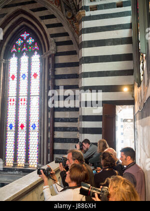 I turisti a scattare foto all'interno del Duomo di Siena durante una visita Foto Stock