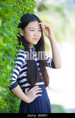 Ritratto di giovane asian teen con emozione la felicità e la faccina sorridente nel parco verde Foto Stock