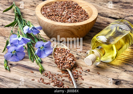 I semi di lino e boccioli di fiore di lino su uno sfondo di legno Foto Stock