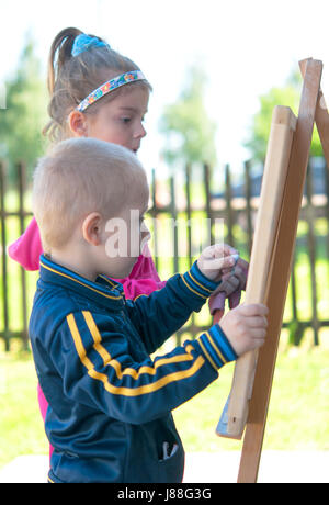 Ragazzo e una ragazza la scrittura con Chalk Foto Stock