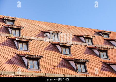 Tetto di tegole con mansarda finestre delle camere attico in antica casa europea Foto Stock