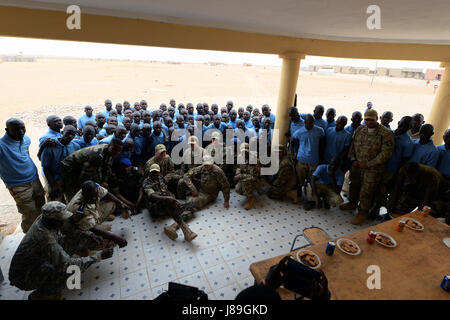 I membri delle forze Armées Nigeriennes ed avieri dispiegato per il 724th Expeditionary Air Base Squadron posano per una foto a Nigerien Air Base 201, Niger, 18 maggio 2017. Avieri sono stati invitati a partecipare alla cerimonia di laurea come un testamento al partenariato tra le due forze armate. (U.S. Air Force foto di Senior Airman Jimmie D. Pike) Foto Stock