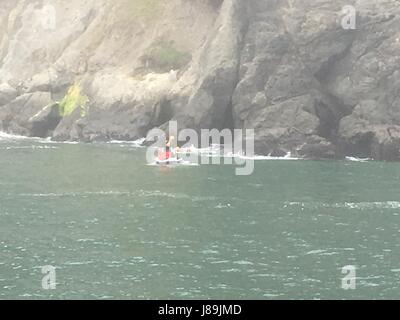 San Francisco Fire membri del dipartimento a bordo di un jet ski assistere un distressed nuotatore vicino a China Beach, 20 maggio 2017, Sabato. Stazione della Guardia costiera Golden Gate e San Francisco Fire Department salvato 2 nuotatori ipotermico. (Coast Guard foto di Sottufficiali di seconda classe Garrett Henderson). Foto Stock