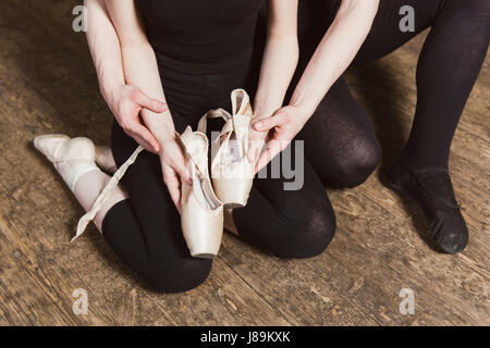 Ballerina e maschio di ballerina azienda scarpe da ballo in mani. Vista superiore foto. Orizzontale. close-up. Foto Stock