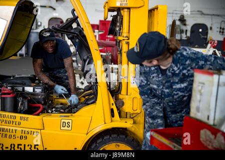 170522-N-QN175-043 Norfolk, Virginia (22 maggio 2017) Aviazione Equipaggiamento di supporto tecnico di terza classe Miguel Hardy aviazione e delle attrezzature di supporto tecnico 2a classe Megan Robbins eseguire interventi di manutenzione su un folk sollevare nella baia di hangar della portaerei USS Dwight D. Eisenhower CVN (69) (IKE). Ike è attualmente pier lato durante la fase di supporto della flotta ottimizzato il piano di risposta (OFRP). (U.S. Foto di Marina di Massa lo specialista di comunicazione di terza classe Dartez C. Williams) Foto Stock