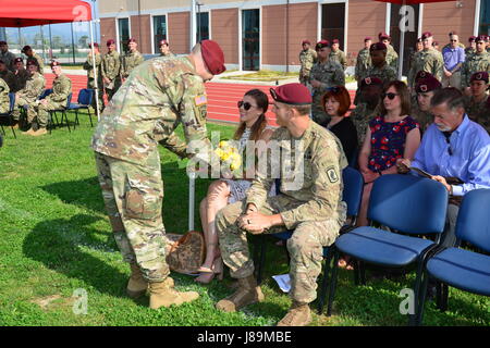 Laura Gerbatsch, moglie del Comandante in arrivo Capt. Travis R. Gerbatsch, riceve un bouquet di fiori gialli da un paracadutista durante la modifica del comando cerimonia di Charlie Company, 54th ingegnere vigili del Battaglione, 173rd Brigata Aerea, alla Caserma del Din a Vicenza, Italia, Maggio 23, 2017. Il 173rd Airborne brigata basata a Vicenza, Italia, è l'esercito di contingenza Forza di risposta in Europa ed è in grado di proiettare le forze per condurre la piena gamma delle operazioni militari in tutto il regno membro unione, centrale e Africa comandi aree di responsabilità. (U.S. Foto dell'esercito da Visual ho Foto Stock