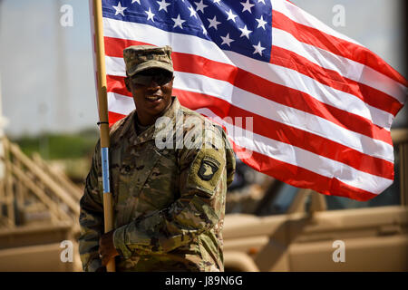 Stati Uniti Il personale dell'esercito Sgt. Anthony Miller con la 101ª Divisione aviotrasportata tiene la bandiera americana durante una cerimonia di consegna dei diplomi per nazionali somale soldati dell esercito 24 maggio 2017, a Mogadiscio, in Somalia. Il corso di logistica incentrati su vari aspetti di spostamento di personale, attrezzature e forniture. (U.S. Air Force photo by Staff Sgt. Nicola M. Byers) Foto Stock