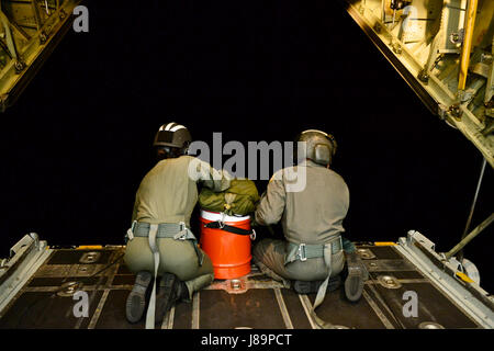 Petty Officer 2a classe Mandi Stevens e sottufficiali di 2a classe di Chris Parmenter, aviazione di tecnici di manutenzione dalla guardia costiera Stazione aria Barbieri punto, sedersi sulla rampa di un HC-130 Hercules aereo per distribuire un intervallo lungo dispiegabile kit di discesa ad un recipiente di disabili circa 80 miglia fuori della Tonga Maggio 25, 2017. L'aria equipaggio stava tornando da una ricerca e soccorso conferenza in Nuova Zelanda e macchiato il recipiente dopo essere stato deviato. (U.S. Coast Guard foto di Sottufficiali di terza classe Amanda Levasseur/rilasciato) Foto Stock