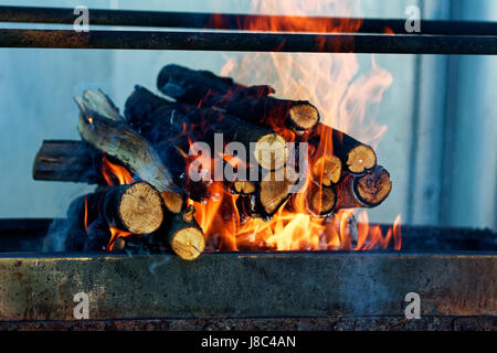 La combustione del legno nel camino closeup. Home caldo arancio falò con dei pezzi di legno Foto Stock