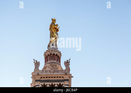 Statua dorata della Madonna che tiene il piccolo Gesù sulla cima di Notre Dame de la Garde a Marsiglia, Francia Foto Stock