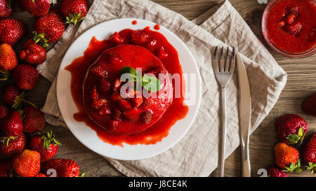 Macro vista superiore american pancake con confettura di fragole su uno sfondo di legno. Grande profondità di campo. Foto Stock