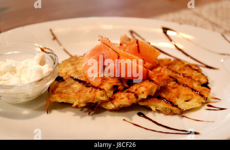 Deliziose frittelle di patate con salmone e panna acida Foto Stock