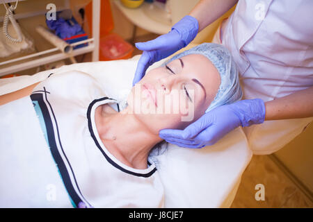 Medico cosmetologo rende una donna massaggio del viso Foto Stock