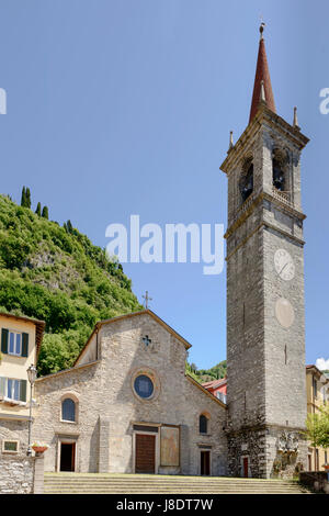 Storica chiesa romanica in villaggio turistico sul lago di Como, girato in una luminosa giornata di primavera a Varenna, Lombardia, Italia Foto Stock