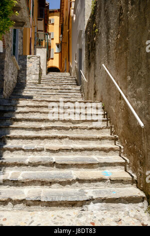 Ripide scale di pietra in stretto vicolo del lago turistico villaggio, girato in una luminosa giornata di primavera a Varenna , Italia Foto Stock