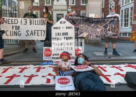 26 maggio 2017 - Londra, Regno Unito - Londra UK. 26 maggio 2017. Un padre pone con il figlio che egli porta sulla sua bicicletta davanti alla lapide a smettere di uccidere i ciclisti veglia di protesta e di morire in fuori il Partito Tory HQ per contrassegnare la morte di circa 280.000 persone dall'inquinamento atmosferico, in gran parte connesse ai trasporti e una stima inoltre 168.000 persone da malattie di inattività a causa di mancanza di ciclo protetta corsie, poiché i conservatori sono stati eletti nel 2017. Essi esigono che il dieci percento del bilancio di trasporto essere speso per pulire con aria protetta dell'infrastruttura di ciclismo da 2020. Una protesta simile ha avuto luogo al di fuori del Foto Stock