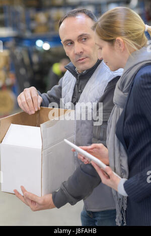 Giovane Operaio di magazzino che si occupa di forniture per edifici Foto Stock