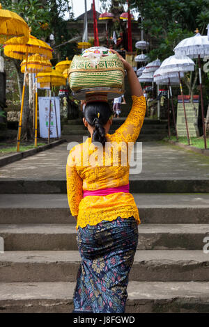 UBUD, Indonesia - 2 Marzo: Donna con cesto sulla testa cammina su per le scale durante la celebrazione prima Nyepi (Giorno Balinese di silenzio) il 2 marzo Foto Stock