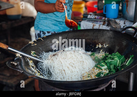 GEORGE TOWN, Malesia - 23 Marzo: Donna cuochi stir-noodles fritti con i germogli di soia presso Kimberly cibo di strada del mercato notturno su Marzo 23, 2016 in George a Foto Stock