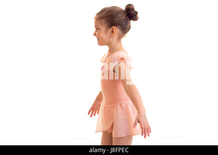 Piacevole piccolo ragazza in abito rosa danza su sfondo bianco in studio Foto Stock