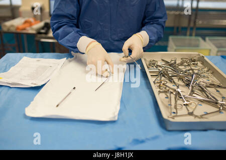 Gli strumenti chirurgici vengono puliti e sterilizzati presso un ospedale da uno strumento chirurgico società sterilizzante Foto Stock