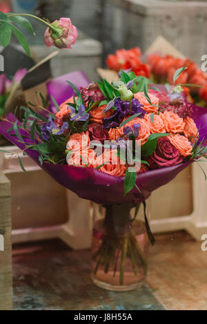 Splendidi bouquet di rose e petali di fiori viola flovers in vaso Foto Stock