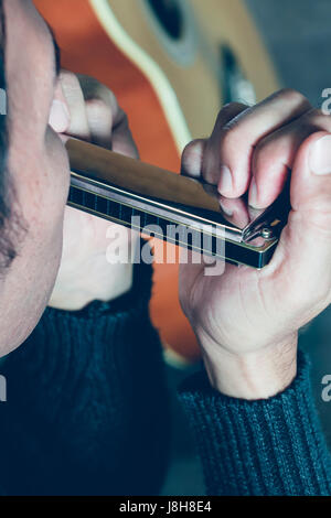 Giovane uomo soffiando harmonica divertimento musicale Foto Stock