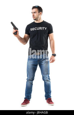 Avvisato cauto abiti informali poliziotto holding gun guardando lontano. Corpo pieno lunghezza ritratto isolato su bianco di sfondo per studio. Foto Stock