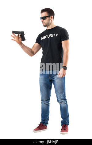 Giovani vestiti semplice poliziotto pistola di filatura sul dito. Corpo pieno lunghezza ritratto isolato su bianco di sfondo per studio. Foto Stock