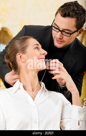 Uomo di dare la sua moglie un pezzo di gioielleria Foto Stock