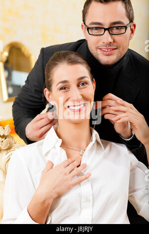 Uomo di dare la sua moglie un pezzo di gioielleria Foto Stock