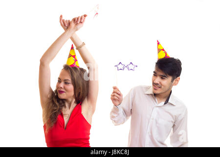 Coppia giovane con la carta i bastoni e celebrando cappelli Foto Stock