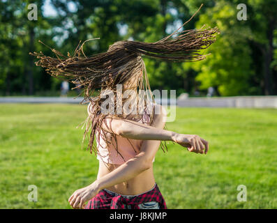 Ragazza con zizi cornrows dreadlocks ballando sul prato Foto Stock