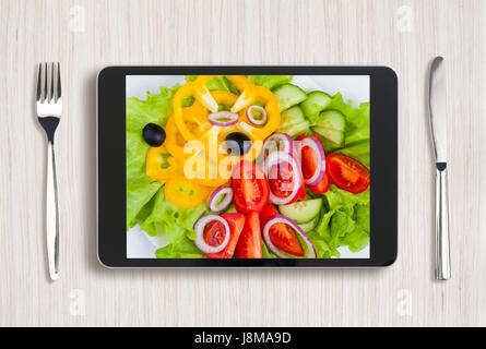 Nero tablet pc con cibo sano sullo schermo e tavolo in legno Foto Stock