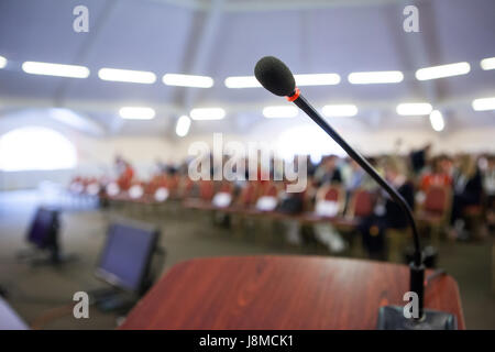 La parola o il concetto di conferenza. Microfono di stare davanti al pubblico. Foto Stock