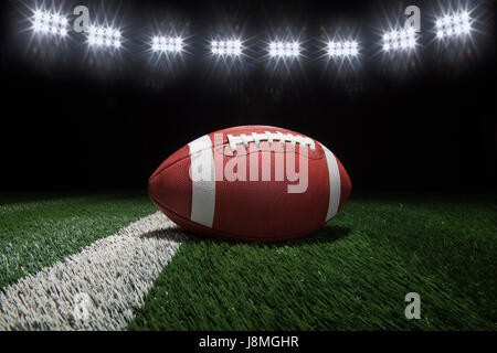 Basso angolo di visualizzazione stile college football su un cortile di linea di un campo di calcio sotto le luci dello stadio Foto Stock