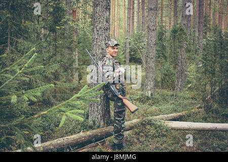 Hunter avente il resto nel bosco durante la stagione di caccia Foto Stock