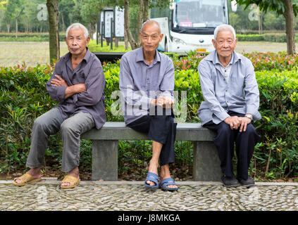 Yubei, Zhejiang, Cina. Tre uomini anziani seduti su una panchina nel parco. Foto Stock