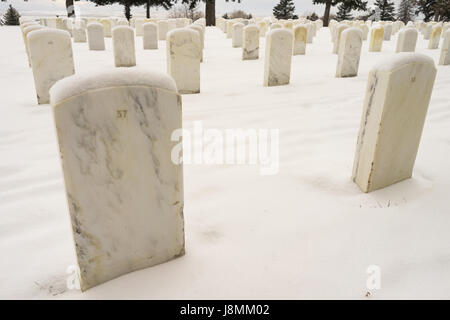 Coperta di neve il terreno e cime di marcatori dove veterani militari sono sepolti a Little Big Horn Foto Stock