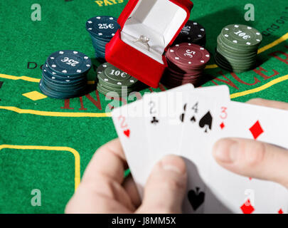 Giocatore di poker che mostra una perdita di combinazione in un poker di carte, uomo beve whiskey dal dolore Foto Stock