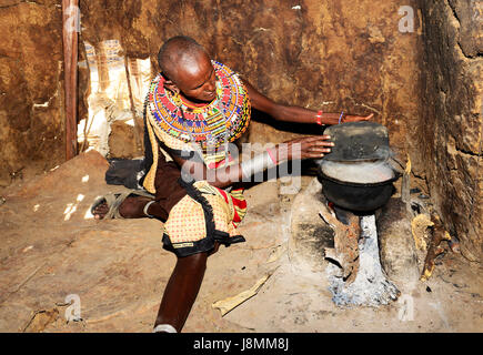 Un Samburu donna la cottura nel suo rifugio in un piccolo villaggio nel nord del Kenya. Foto Stock