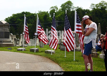 Westminster, Maryland, Stati Uniti d'America. 29 Maggio, 2017. Una donna sta in piedi di fronte ad una linea di bandierine americane nel cimitero durante eventi ufficiali per il Memorial Day, una vacanza federale degli Stati Uniti per ricordare coloro che morirono mentre erano in servizio nelle forze armate. Credito: James Brunker/Alamy Live News Foto Stock