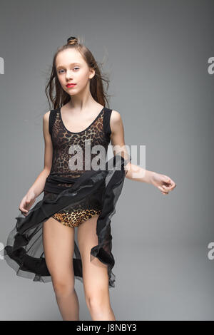 Carino ragazza giovane dancing. Il modello è vestito di nero e leopard pattern abito danza. labbra rosse. Foto Stock