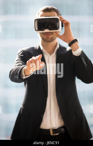 Imprenditore indossando occhiali VR e toccante aria Foto Stock