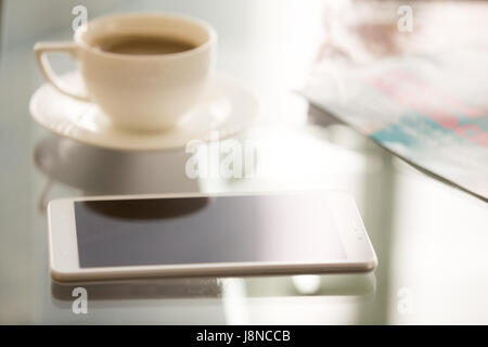 Chiudere l immagine di smartphone alla moda sulla scrivania in vetro Foto Stock